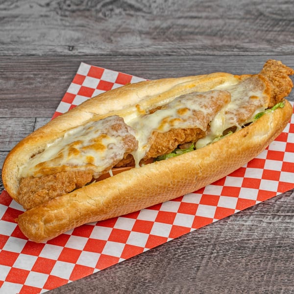 A crispy fried chicken sandwich with melted cheese and lettuce on a sub roll.