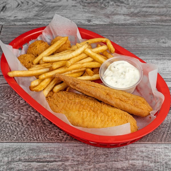 Fried fish fillets, hush puppies, and french fries with tartar sauce in a red basket.
